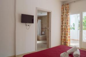 埃斯普霍斯拉戈普拉亚酒店的一间卧室配有一张床,墙上配有电视