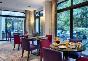 巴黎爱丽舍花园酒店的用餐室设有桌椅和窗户。