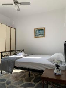 圣罗曼诺斯Sea and Sun Villa的一间卧室配有一张带风扇和一张桌子的床。