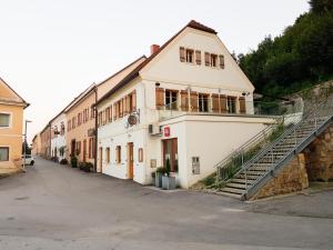 上拉德戈纳Fado Apartments Gornja Radgona的一座白色的建筑,前面有楼梯