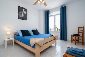 安波拉Apartamento Aigua Blava的一间卧室配有一张带蓝色床单的床和一扇窗户。