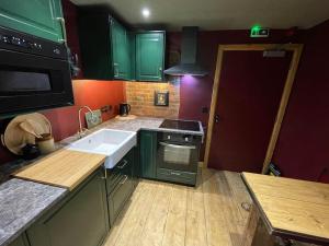 WhaplodeThe Fuggle的厨房配有绿色橱柜和白色水槽