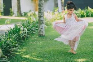 科伦坡水晶别墅的穿着粉红色衣服的小女孩在草地上跳舞