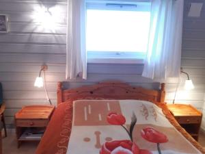 RøyrvikFjord side apartment的一间卧室,床上有红色的鲜花