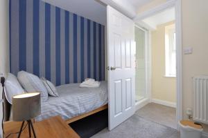 WellingoreThe Little Lion Inn, Red Lion的一间卧室配有一张带蓝色条纹墙的床