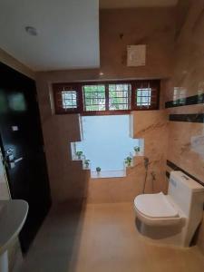 VaikomAnandam Stays - Premium 3BHK plush homestay, Vaikom near Kumarakom的一间带卫生间的浴室和大窗户