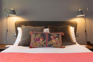 比斯特Jersey Arms Hotel Bicester的一张带两盏灯和两个枕头的床