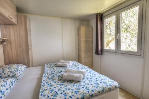 布伦佐内堡Agricampeggio Relax Maxicaravan的一间卧室配有带毛巾的床