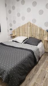 蓬托尔松Les Fauvettes的一间卧室配有一张大床和木制床头板