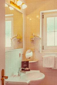 卡尔达罗Amadeus Ora & Amore的一间带水槽和镜子的浴室