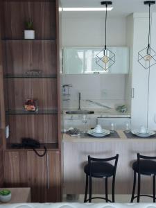 若昂佩索阿Tambaú Flat Belo Mar - Cabo Branco - ANÚNCIO NOVO的厨房配有两把椅子和带玻璃杯的柜台