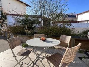 康博莱班Appartement Cambo-les-Bains, 2 pièces, 2 personnes - FR-1-495-12的一张白色的桌子和椅子,上面放着一碗水果