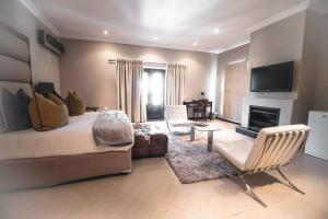 哈博罗内卡皮塔尔旅馆的一间卧室设有一张床,客厅设有壁炉。