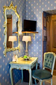 罗马玛利亚圣劳伦佐别墅酒店的配有桌子、镜子和椅子的房间