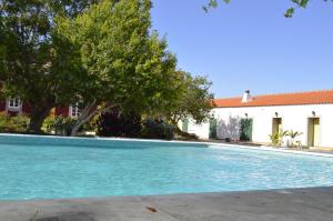 斯代塔维拉Hortas de Baixo的一座树木繁茂的游泳池和一座建筑