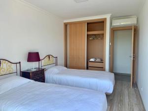 斯代塔维拉Hortas de Baixo的一间卧室设有两张床,一扇门通往一个衣柜。