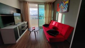 若昂佩索阿Flat à beira mar, charmoso e aconchegante的客厅配有红色沙发和电视