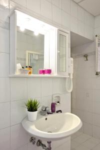 罗马玛利亚圣劳伦佐别墅酒店的白色的浴室设有水槽和镜子