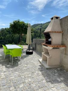 吉尔斯Cantinho Verde T3的一个带桌子和户外烤箱的庭院