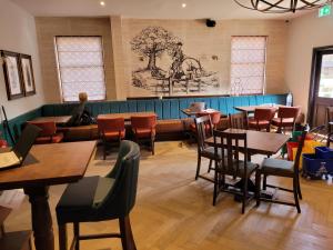 KnebworthThe Chequers Inn的一间带木桌和椅子以及长凳的餐厅
