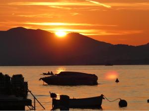 拉多维奇Monténégro, villa dans la baie de Kotor, avec plusieurs appartements tout confort en front de mer!的船在水体上日落