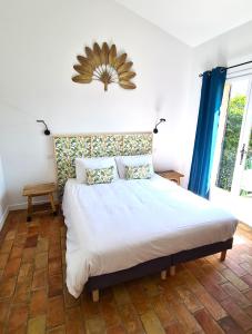 圣保罗-德旺斯Villa Martinus的卧室配有一张带蓝色窗帘的大型白色床