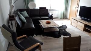 瓦尔施泰因Ferienwohnung 43qm Torf 10 nähe Möhnesee的客厅配有黑色沙发和桌子