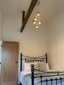 达灵顿Barford barn holiday cottage的一间卧室配有一张床和一个吊灯