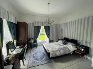 穆林加尔Glenmore House B&B Mullingar的一间卧室配有一张床、一张书桌和一个窗户。