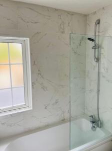 阿夫雷Wadhurst - Stunning 4 bed (all en-suite) house的带淋浴的浴室,配有窗户和浴缸