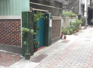 台南南惰 的砖墙,有蓝色的门,上面有植物