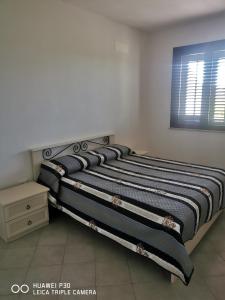 伯吉维奇Case vacanze Baglio Sances的卧室里一张带条纹毯子的床