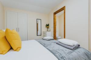 诺丁汉Cosy 2nd Floor Apartment - King Size Bed & Free Parking的白色卧室配有一张白色大床和黄色枕头