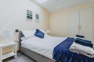 诺丁汉Spacious 2nd Floor Apartment - King Size Bed & Free Parking的一间卧室配有一张带蓝色床单的床和一张书桌。