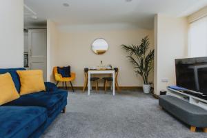 诺丁汉Spacious 2nd Floor Apartment - King Size Bed & Free Parking的客厅配有蓝色的沙发和桌子
