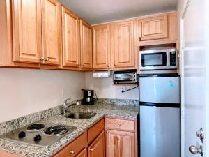 波士顿Copley House Extended Stay的一间带木制橱柜和冰箱的小厨房