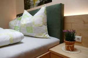 马伦格Der Luemerhof的一张带枕头的床和一张桌子上的盆栽植物
