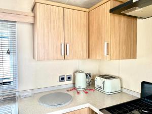 惠茨特布尔The Windermere的厨房配有木制橱柜、烤面包机和烤面包机。
