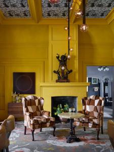 希尔兹堡The Madrona的客厅配有两把椅子和壁炉
