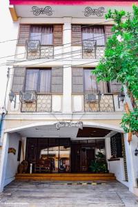 美岸Casa De Soledad Vigan City的一座带窗户和门廊的白色大建筑