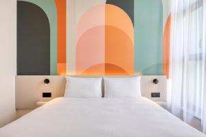 哈瑟尔特B&B HOTEL Hasselt的一间卧室设有一张床和色彩缤纷的墙壁