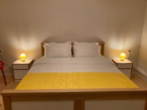 博尔若米Borjomi Yellow Hotel的一间卧室配有一张床,两台桌子上放着两盏灯