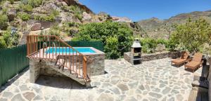 克鲁兹·德·特赫达Casita el Parral的一个带游泳池和两个长椅的庭院