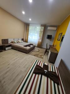 德里亚诺沃Семеен хотел Аристо的一间大房间,配有床和地毯