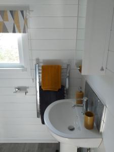 马盖特Delightful cosy cabin的白色的浴室设有水槽和窗户。
