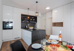伊穆尼Apartment Mia Šimuni的厨房配有白色橱柜和酒杯桌子