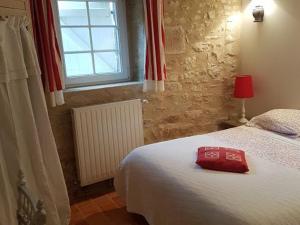 ArçonnayGîte Arçonnay, 6 pièces, 14 personnes - FR-1-410-300的一间卧室,床上有红色的袋子