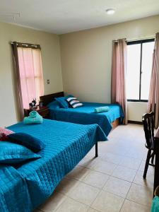 利比里亚Apartamento The Garden的一间卧室配有两张带蓝色床单的床