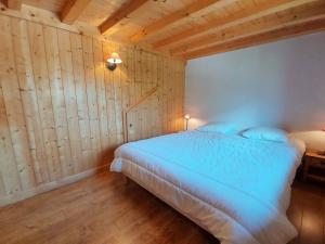 萨莫安斯Appartement Samoëns, 2 pièces, 5 personnes - FR-1-624-42的卧室配有一张床铺,位于带木墙的房间内