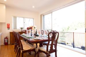 肯图巴The roses house - Cozy and Modern house in Katoomba的一间带桌椅的用餐室和一个阳台